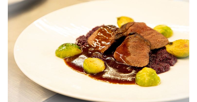 Roasted wild boar fillet on red cabbage purée and steamed Brussels sprouts