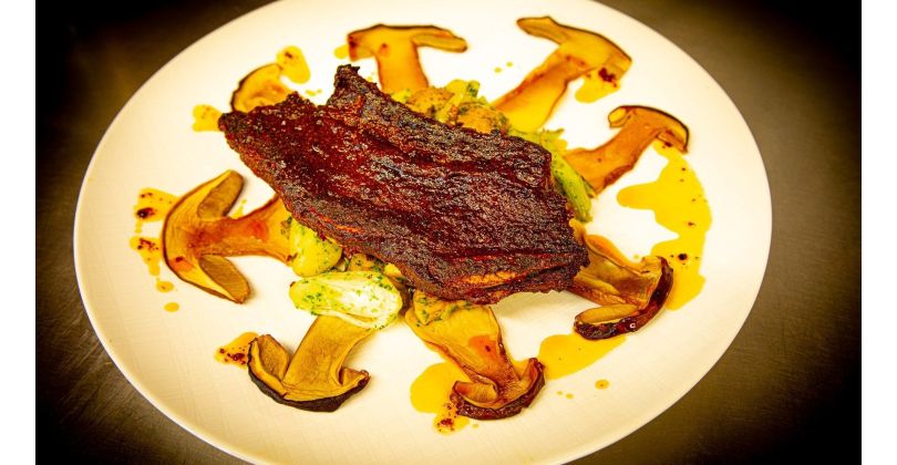Crispy grilled beef asados with meat4you seasoning and marinated porcini mushrooms on a roasted potato, onion, and mushroom bed