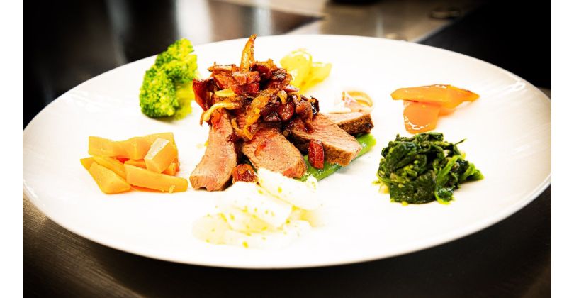 Grilled Denver Cut Steak from a cast iron pan with fresh vegetables and sautéed chorizo, chanterelles, and onions