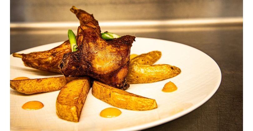 Crispy oven-baked rabbit pieces with fried potatoes and cocktail sauce with cognac