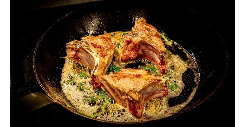Roast lamb chops on risotto with red chicory with seeds and spinach