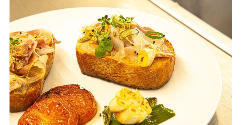 Iberischer Lardo auf geröstetem Bauernbrot mit Honig, Rosmarin und gebratenen Tomaten