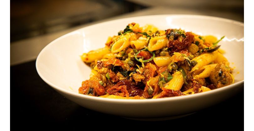 Pasta with squeezed Mediterranean pork sausage, olives, sun-dried tomatoes and capers in a spicy tomato sauce