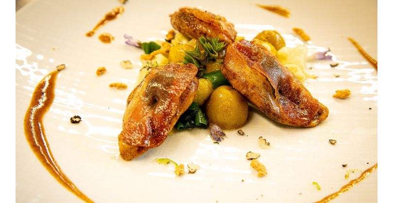 Gebratene Rebhuhnbrust-Saltimbocca mit sautierten Blumenkohlrosen, Frühlingszwiebeln, Knoblauch und neuen Kartoffeln, serviert mit kräftigem, getrüffeltem Wildfond
