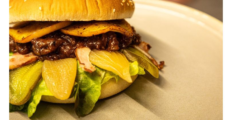 Braised and Pulled Oxtail Burger with Apple BBQ Sauce, Fried Onions, Crispy Bacon, and Grilled Apple Slices