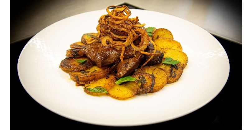 Fried beef liver patties with fried onions, fried potatoes and balsamic sauce