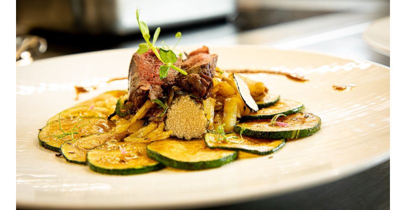 Braised wild pigeon breast on fried zucchini rounds, crispy and grated potatoes, shaved black summer truffle, and fresh game jus