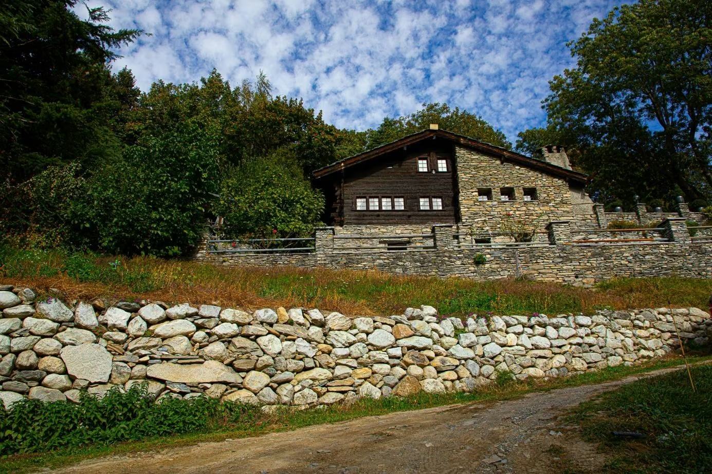 Hofgebäude oberhalb einer Natursteinmauer in Raron